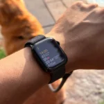 Apple Watch trên cổ tay người đàn ông hiển thị ứng liệu tập luyện và chỉ số sức khỏe, minh họa tính năng theo dõi thể chất của đồng hồ thông minh.
