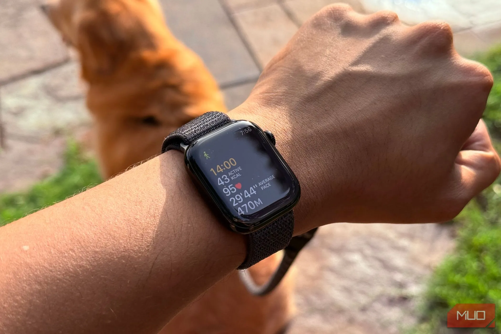 Apple Watch trên cổ tay người đàn ông hiển thị ứng liệu tập luyện và chỉ số sức khỏe, minh họa tính năng theo dõi thể chất của đồng hồ thông minh.