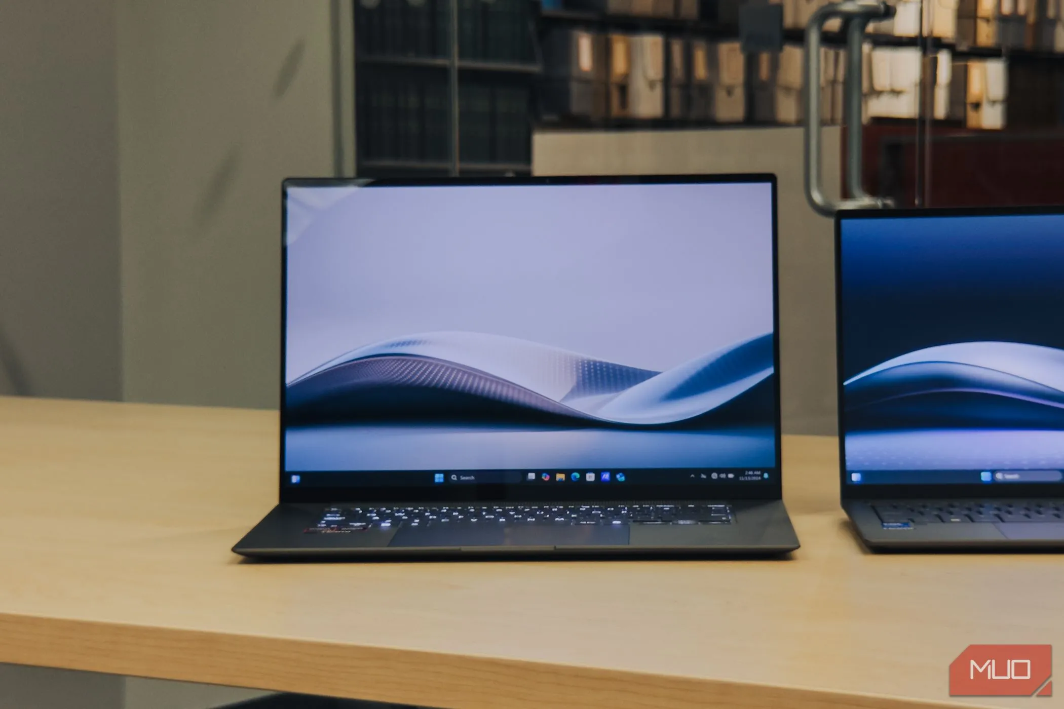 ASUS Zenbook S 16 OLED đặt trên bàn gỗ với màn hình đang bật