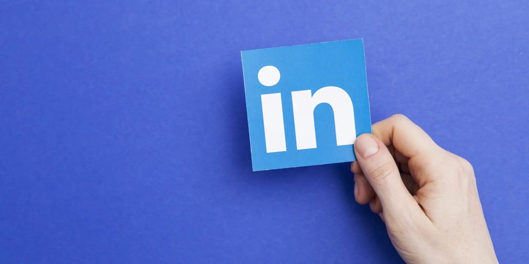 Biểu tượng LinkedIn được cầm trên tay, cho thấy mạng xã hội chuyên nghiệp này thu thập lượng lớn thông tin và sử dụng cho AI