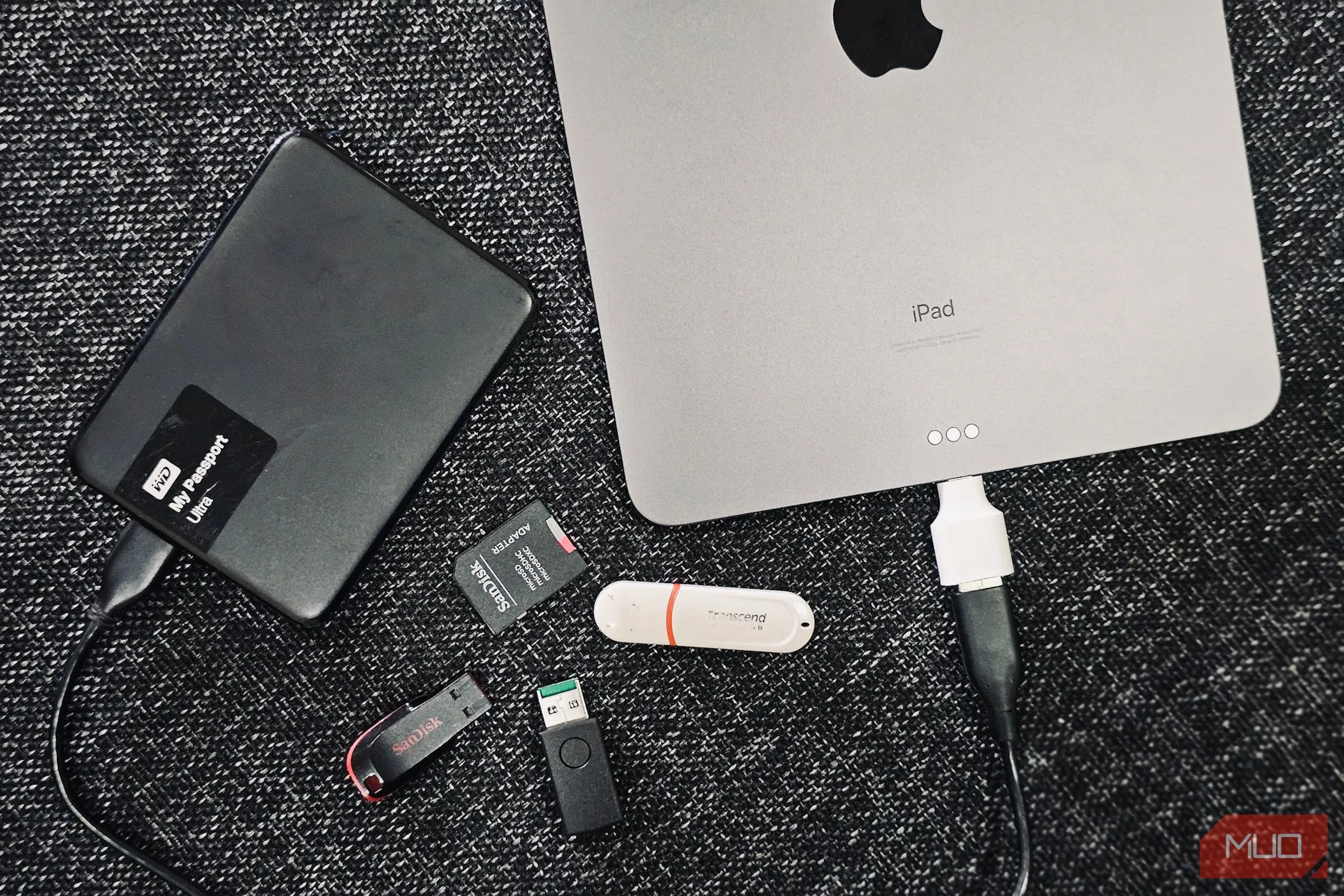 Các ổ đĩa ngoài và một iPad, minh họa việc sao lưu dữ liệu vào thiết bị lưu trữ vật lý.