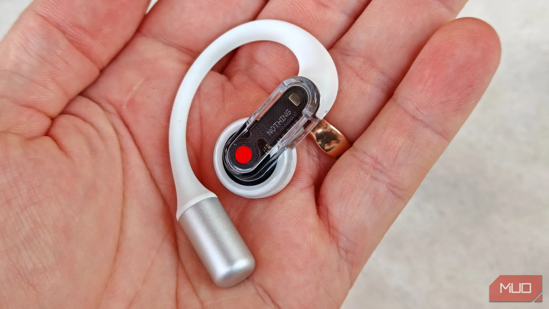 Cận cảnh tai nghe Nothing Ear (open) bên phải được cầm trong tay, minh họa thiết kế và khả năng điều khiển