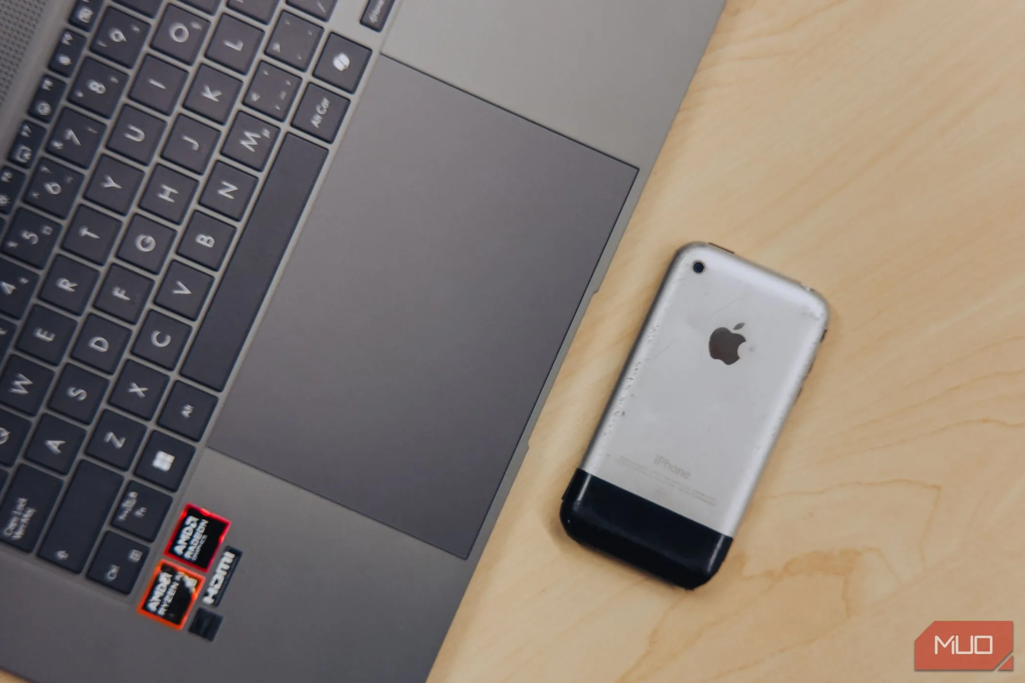 Cận cảnh trackpad ASUS Zenbook S 16 OLED đặt cạnh iPhone 2G