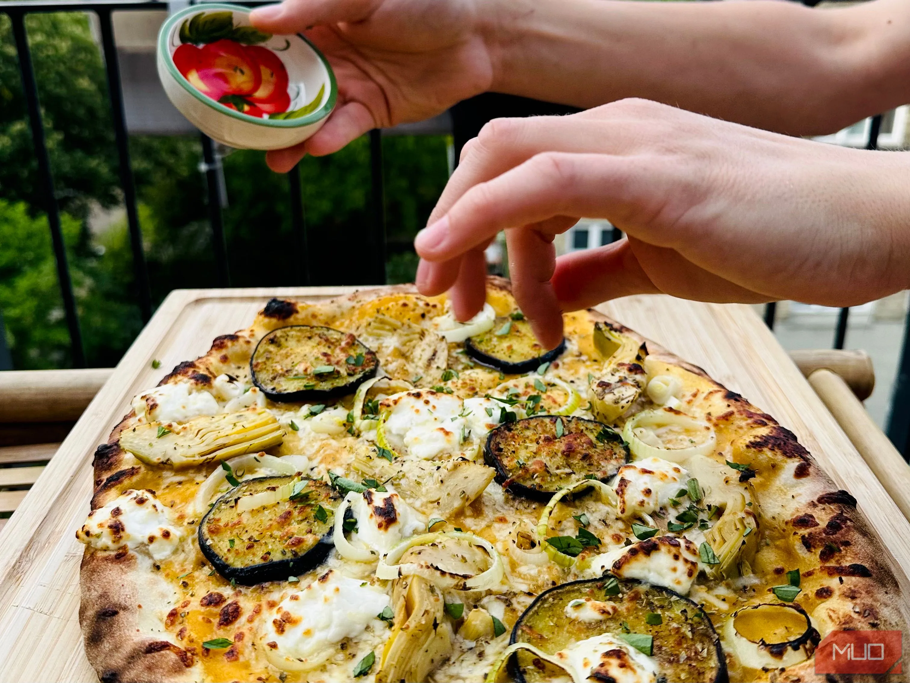 Cảnh làm pizza tại nhà cùng bạn bè, minh họa cách biến bữa ăn thành cơ hội chụp ảnh đầy kỷ niệm và ấm cúng