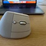 Chuột không dây Logitech Lift gần máy tính xách tay, tối ưu công thái học cho làm việc từ xa.