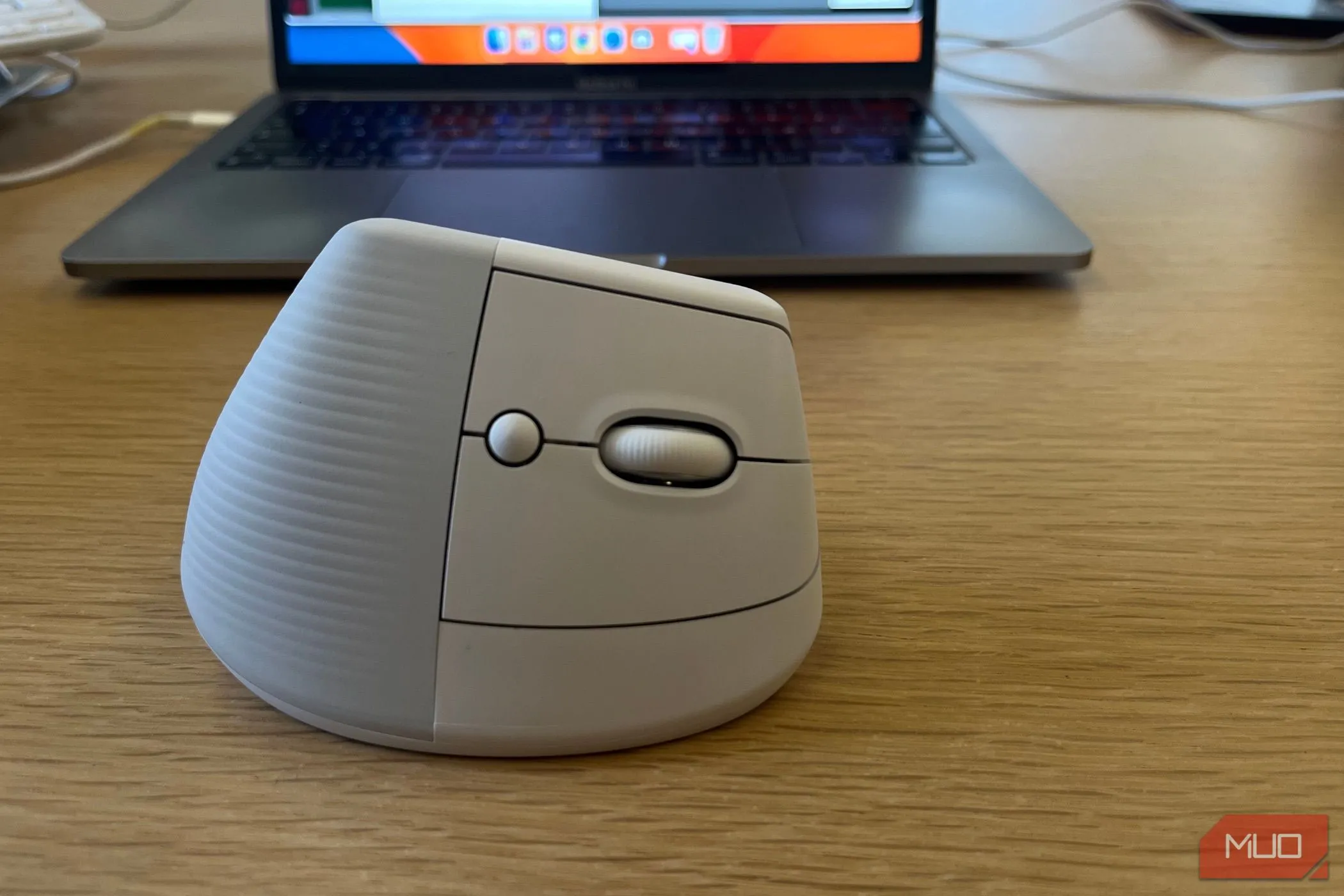 Chuột không dây Logitech Lift gần máy tính xách tay, tối ưu công thái học cho làm việc từ xa.