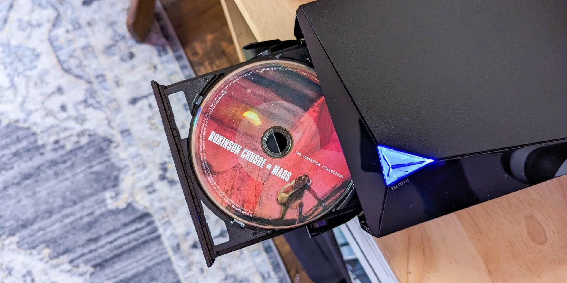 Đầu đĩa DVD Asus với một đĩa phim trong khay, sẵn sàng để kết nối với màn hình máy tính.