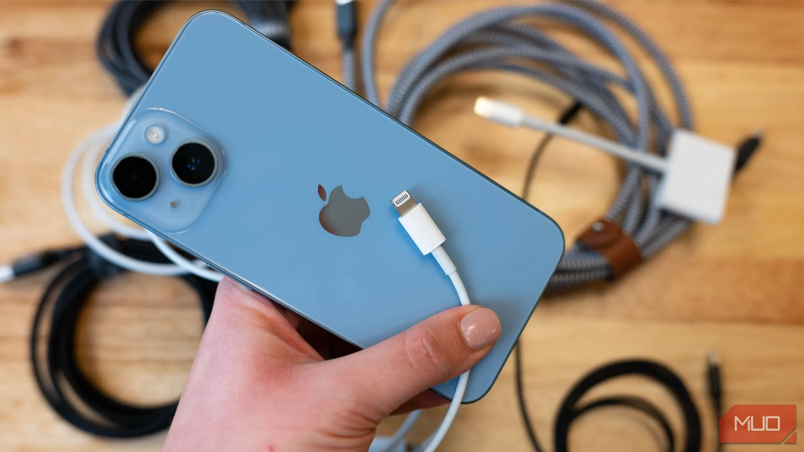Điện thoại iPhone 13 đặt cạnh cáp sạc Lightning, minh họa thói quen sạc nhanh tiện lợi trong các khoảng thời gian ngắn.