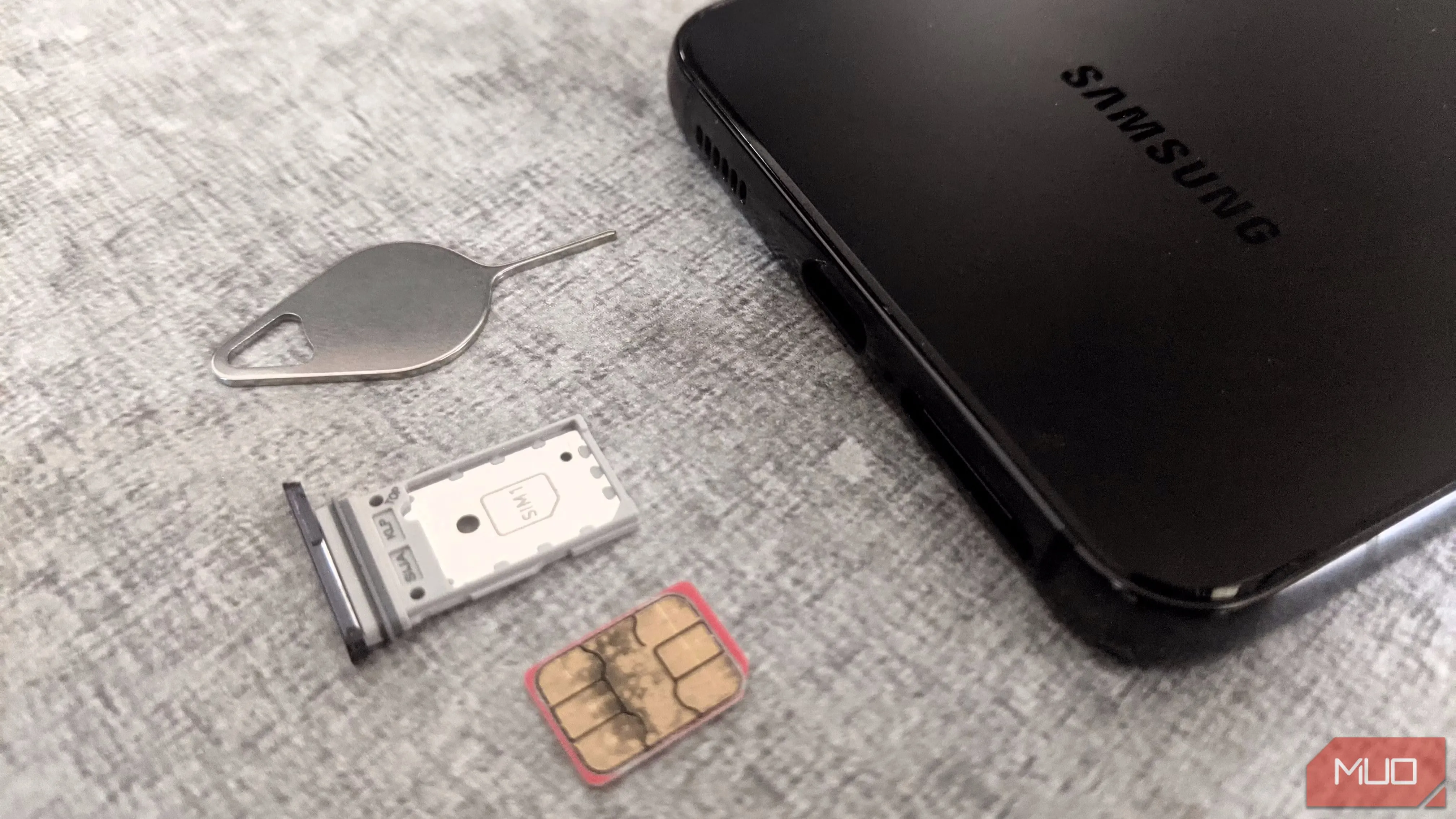 Điện thoại Samsung với khay SIM và que chọc SIM, hình ảnh liên quan đến các cuộc tấn công đổi SIM (SIM-swapping) nhằm chiếm đoạt tài khoản.