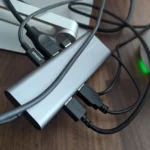 Hình ảnh một dock USB-C thông thường với nhiều dây cáp kết nối lộn xộn, cho thấy sự thiếu gọn gàng khi sử dụng.