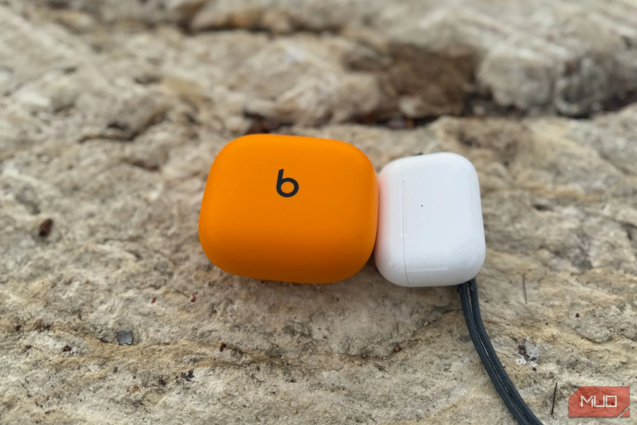 Hộp sạc Powerbeats Pro 2 và AirPods Pro 2 đặt cạnh nhau.
