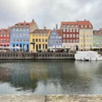 Kênh đào Nyhavn với các ngôi nhà nhiều màu sắc phản chiếu trên mặt nước dưới bầu trời u ám