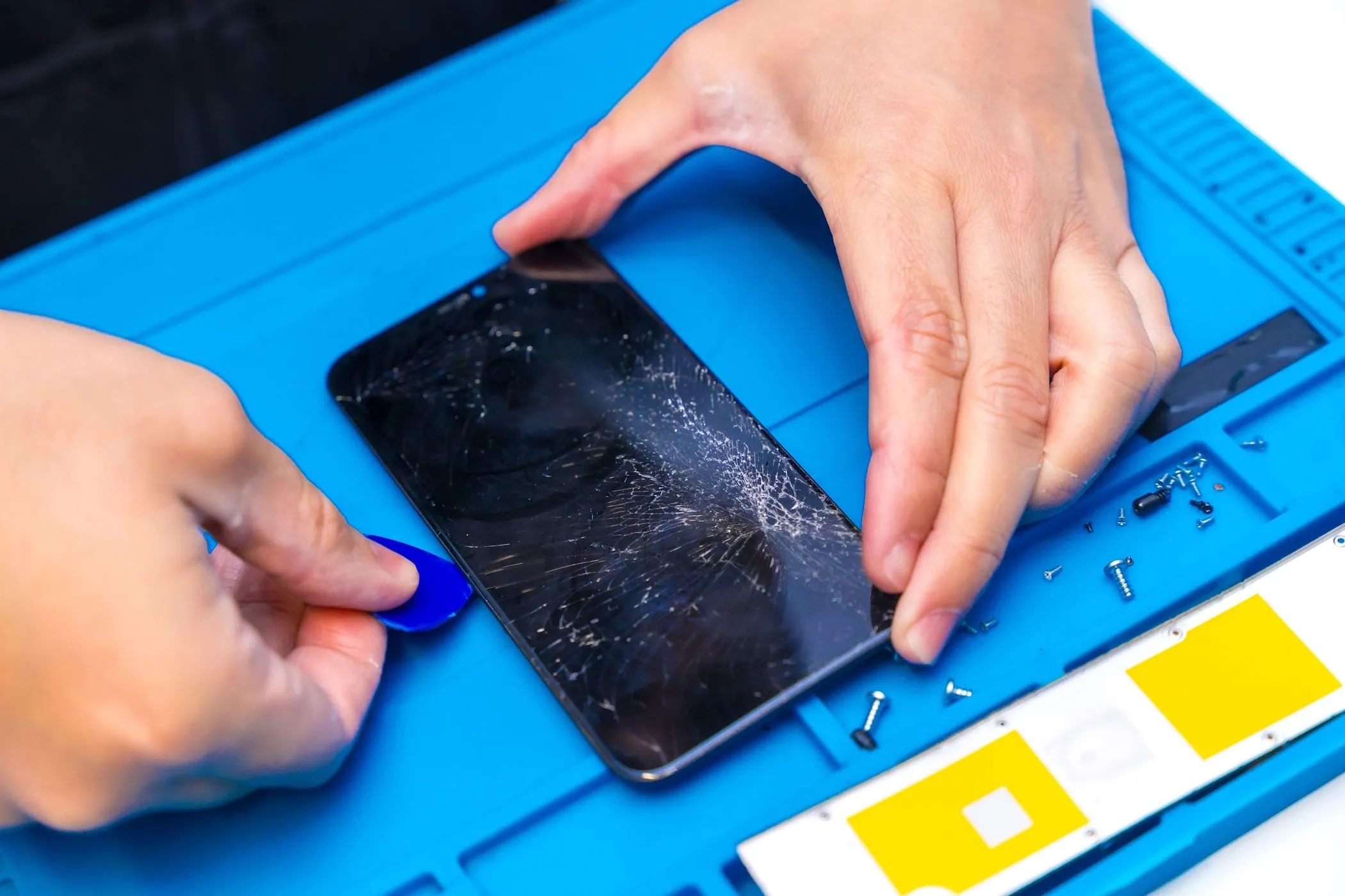 Kỹ thuật viên đang kiểm tra và sửa chữa điện thoại smartphone tại trung tâm bảo hành ủy quyền