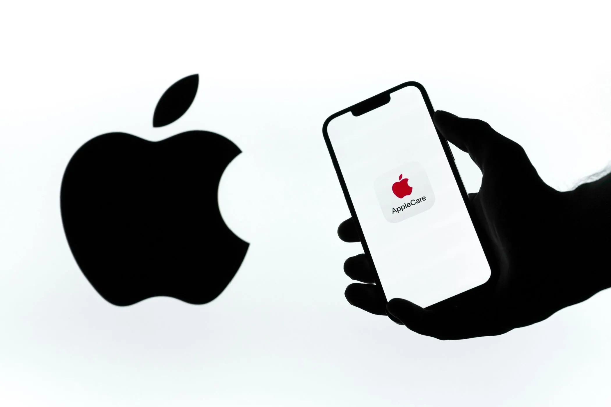 Logo AppleCare+ trên màn hình điện thoại cạnh logo Apple, biểu tượng của dịch vụ bảo hành.