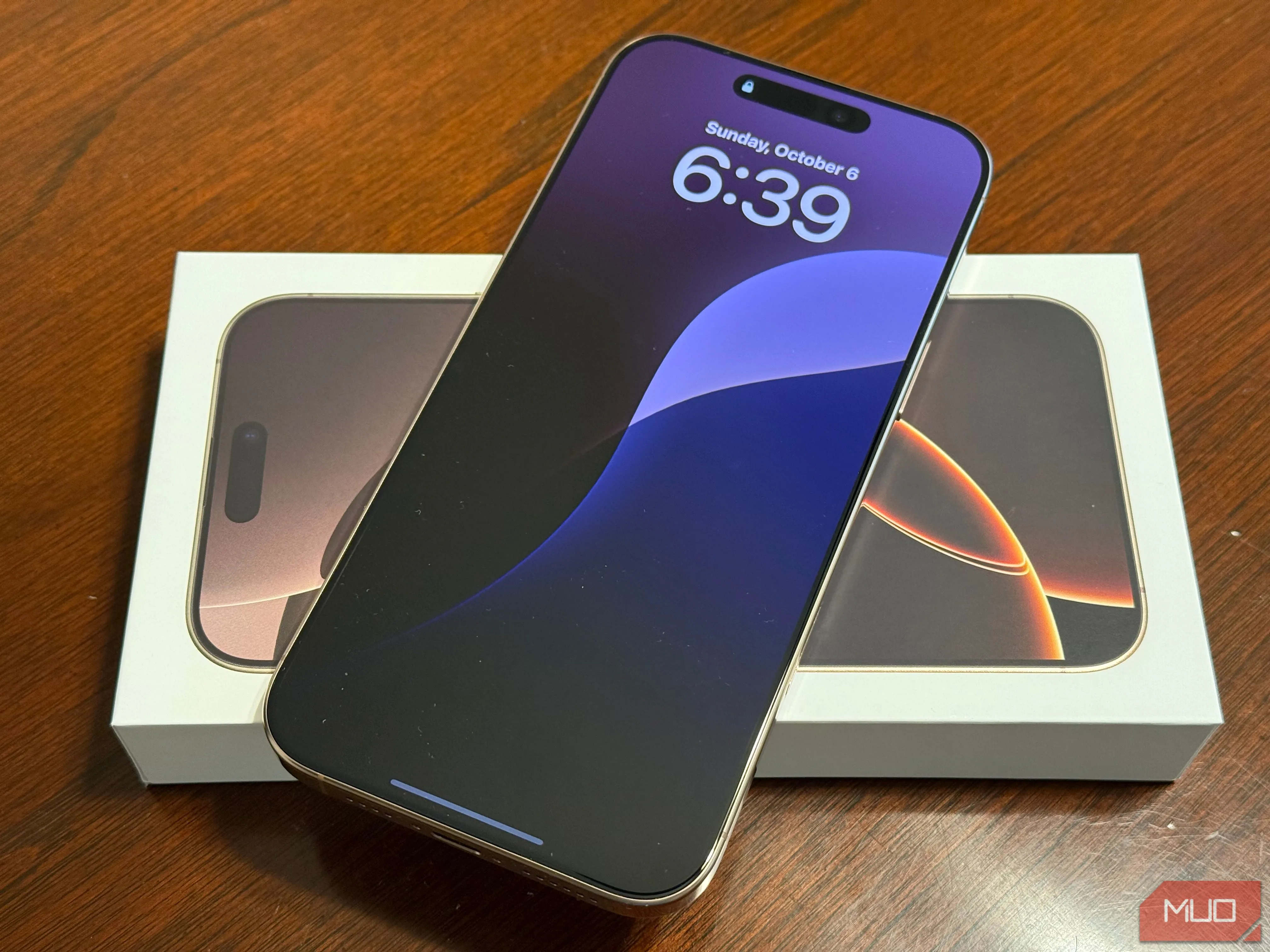 Màn hình khóa iPhone 16 Pro Max với hình nền ấn tượng trên bàn làm việc, thể hiện thiết bị chạy Apple Intelligence.