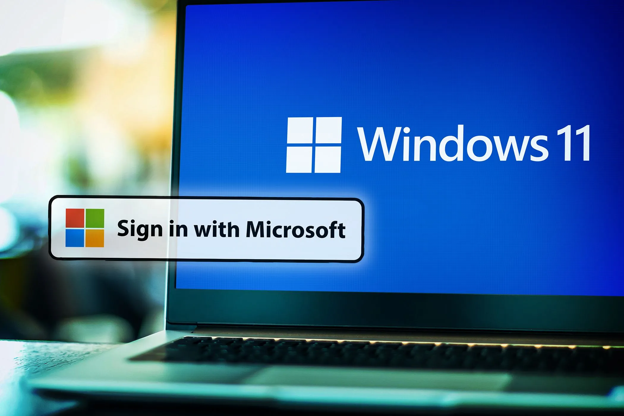 Màn hình laptop hiển thị Windows 11 cùng các logo đăng nhập của Google, Facebook, Apple, minh họa sự đa dạng nhưng khó khăn khi chuyển đổi nhà cung cấp đăng nhập.