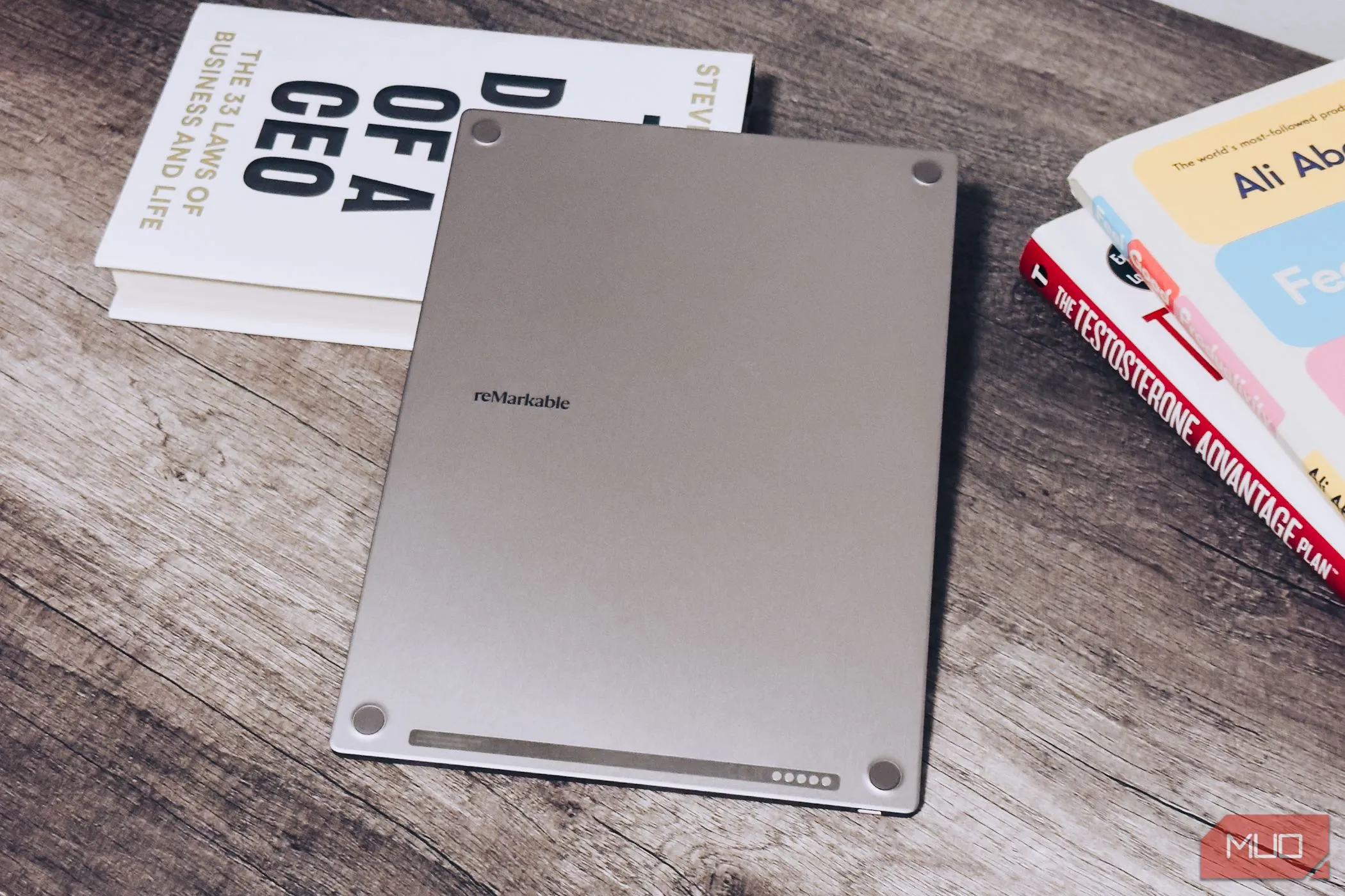 Mặt sau của reMarkable Paper Pro trên bàn gỗ cạnh sách