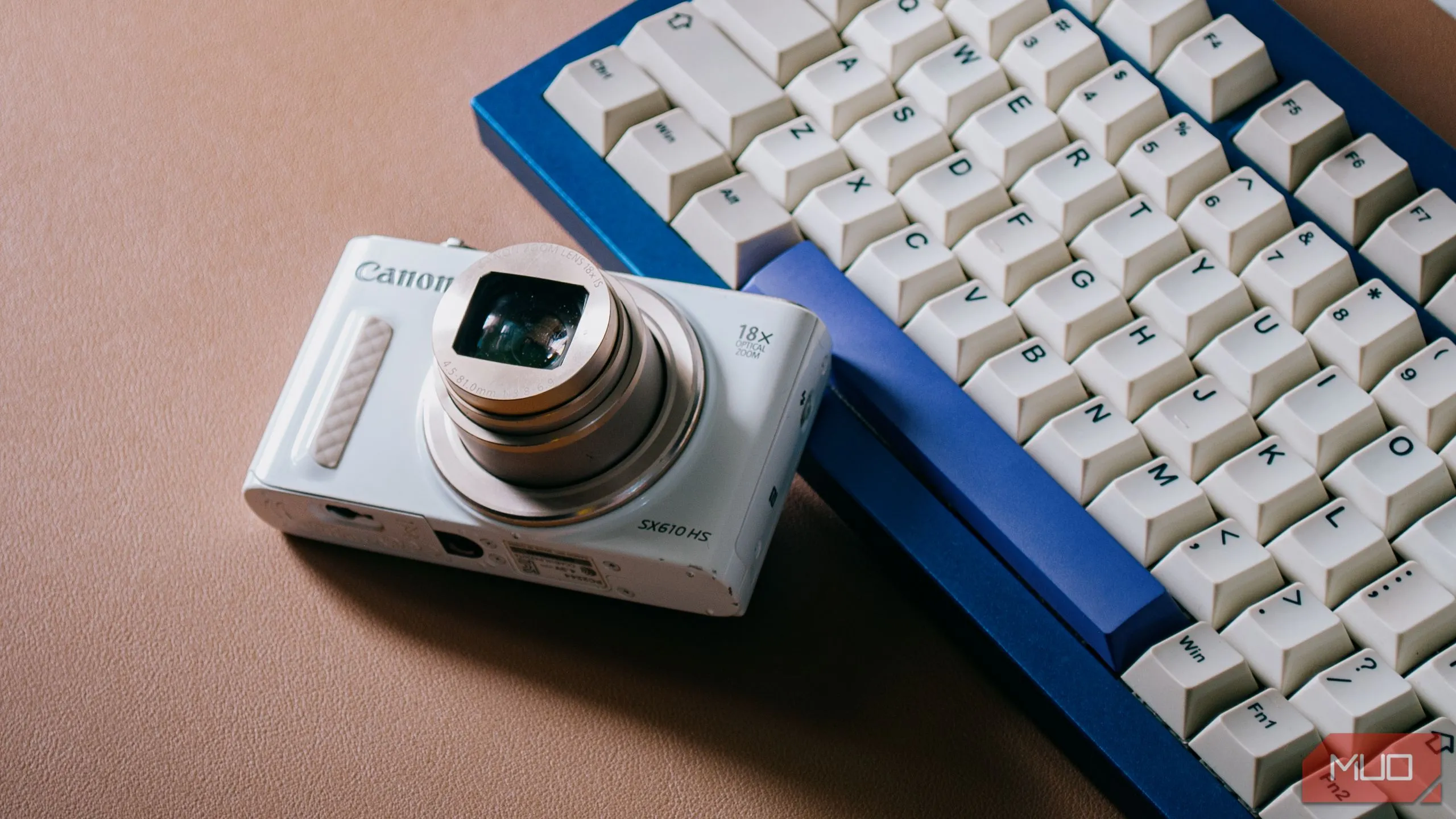 Máy ảnh digicam đặt trên bàn phím máy tính, ống kính đã nhô ra