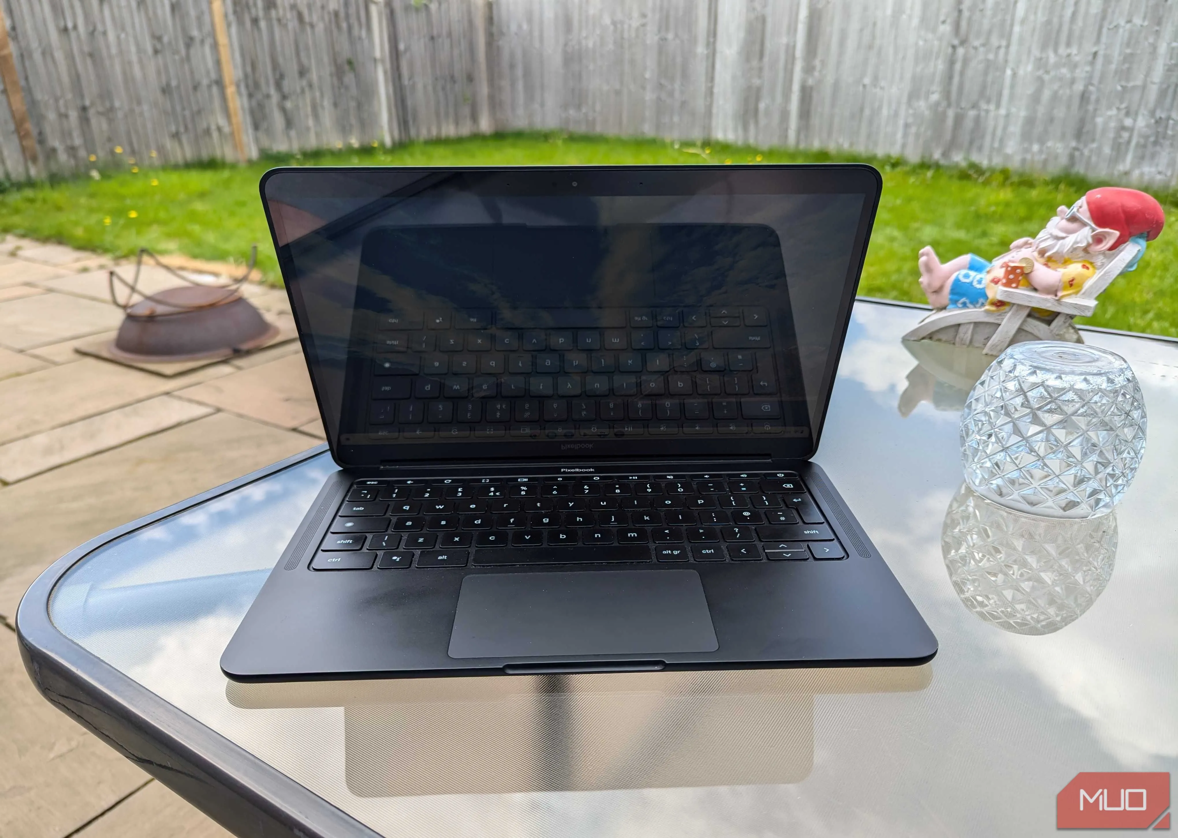 Máy tính Chromebook đang mở đặt trên bàn gỗ trong vườn, thể hiện khả năng khởi động nhanh và sẵn sàng sử dụng mọi lúc