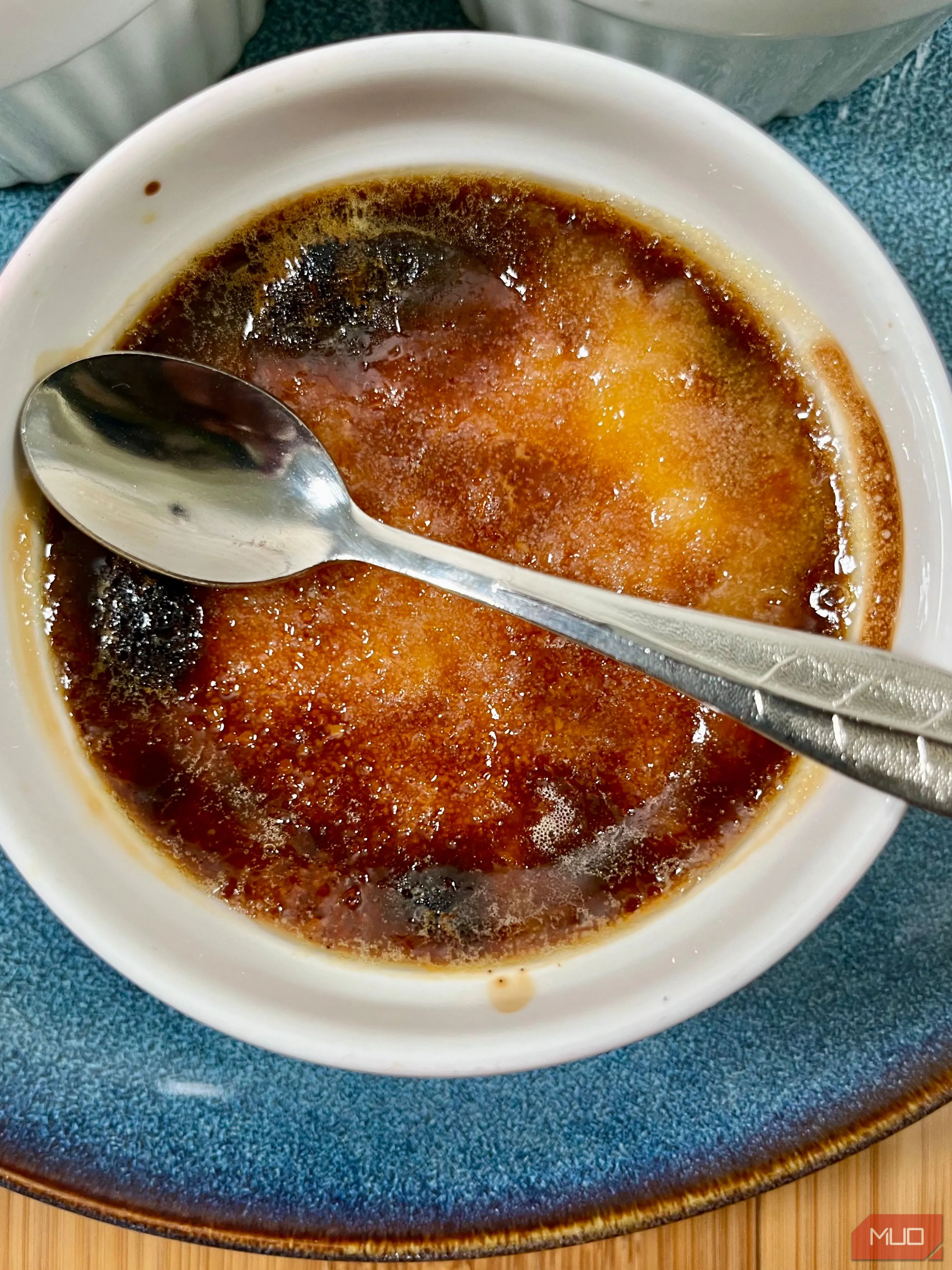 Món kem cháy Creme Brulee được đặt dưới ánh sáng mờ ảo, tạo không khí ấm cúng và tập trung vào lớp đường caramel bóng loáng.