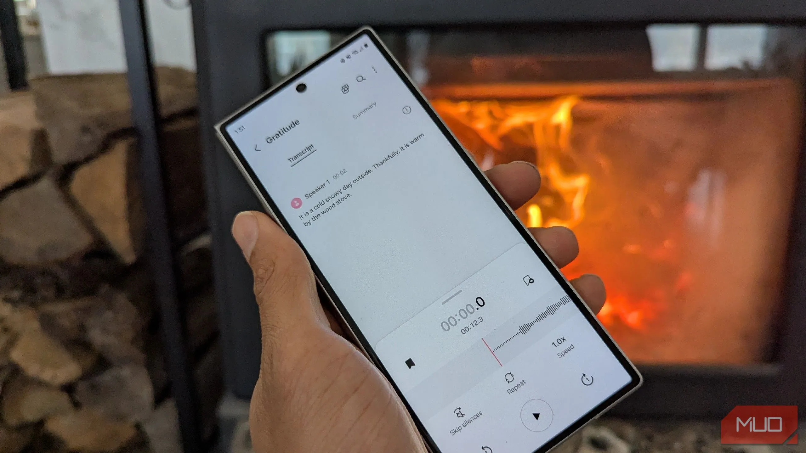Một bản ghi âm giọng nói đang được chuyển đổi thành văn bản bên cạnh lò sưởi gỗ, minh họa sự linh hoạt khi làm việc.