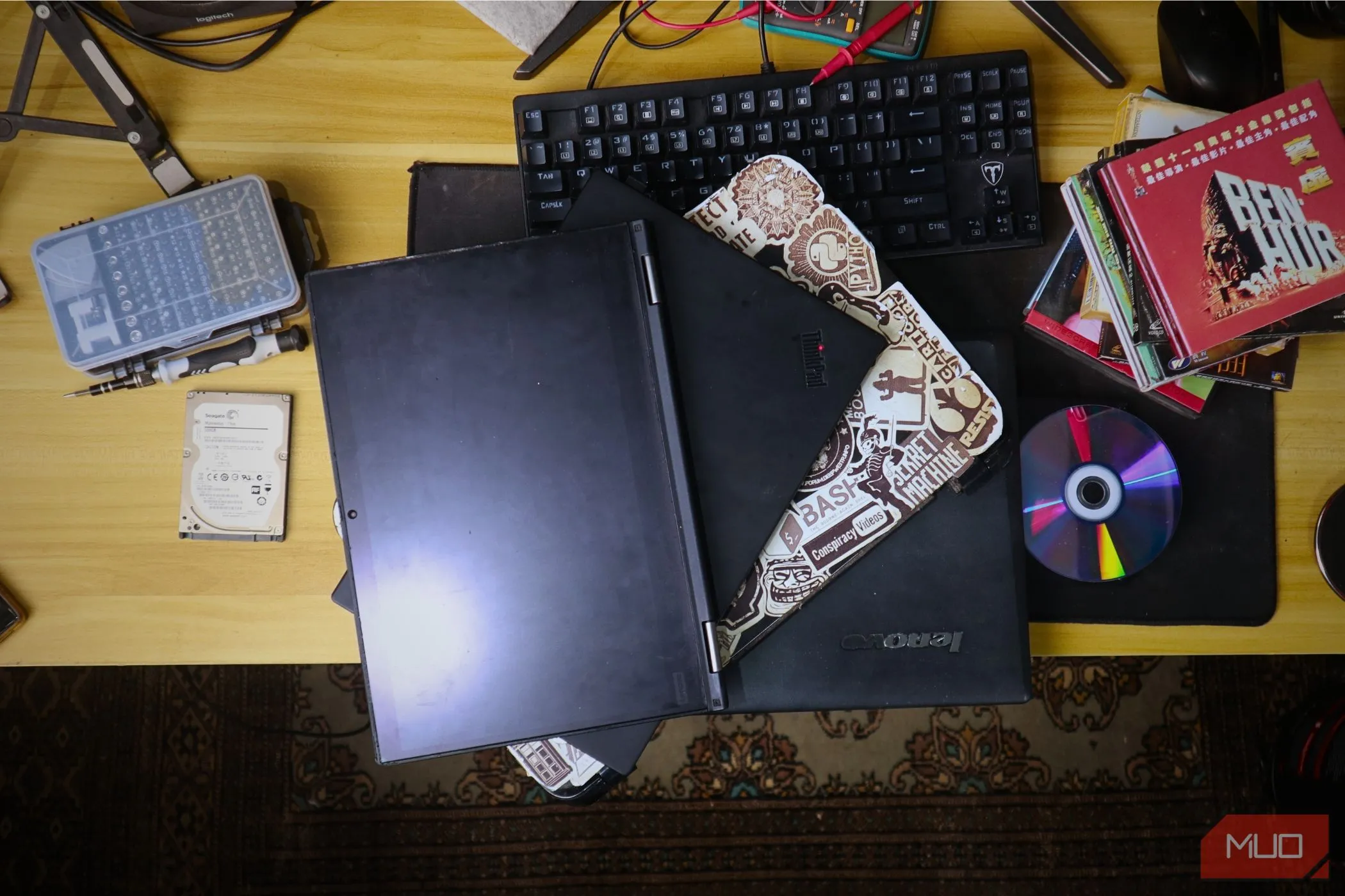 Một chồng laptop cũ kỹ chồng lên nhau, tượng trưng cho việc sử dụng thiết bị lạc hậu có thể làm sai lệch kết quả kiểm tra tốc độ internet do giới hạn phần cứng.