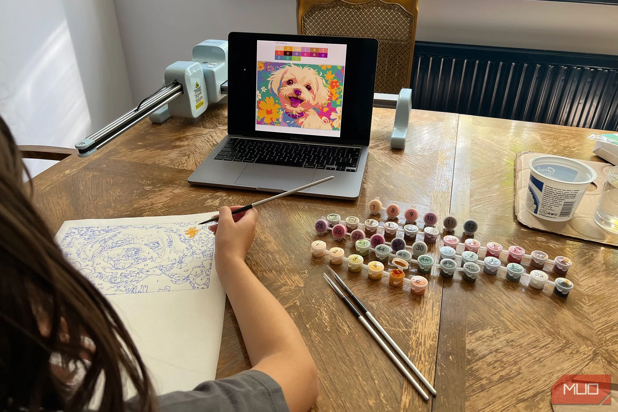 Một em bé đang tô màu bức tranh chó được tạo bởi máy LOKLiK iPaint.