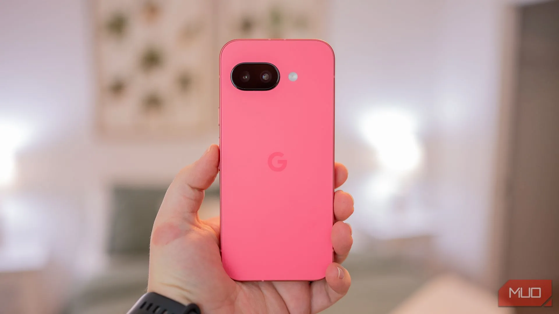Một người đang cầm Google Pixel 9a, khoe mặt lưng máy với thiết kế tối giản và cụm camera được tinh gọn.