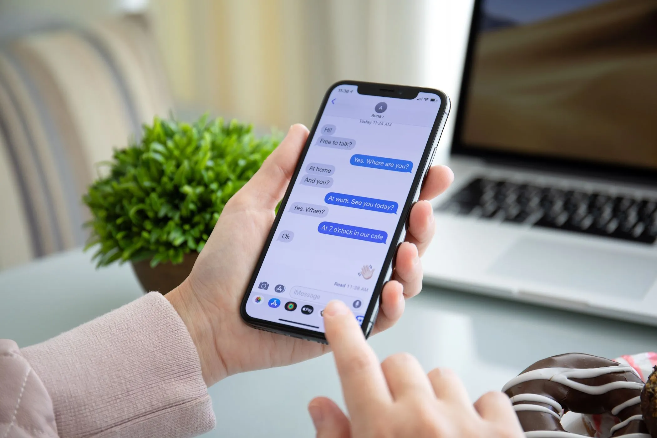 Một người phụ nữ đang sử dụng iMessage trên iPhone, làm nổi bật tính năng độc quyền của hệ sinh thái Apple và vấn đề tương thích tin nhắn đa nền tảng