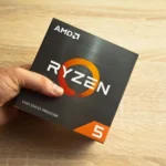 Người đàn ông cầm hộp bộ vi xử lý AMD Ryzen 5 series 5000, minh họa cho việc chọn CPU mạnh mẽ cho laptop giá rẻ.