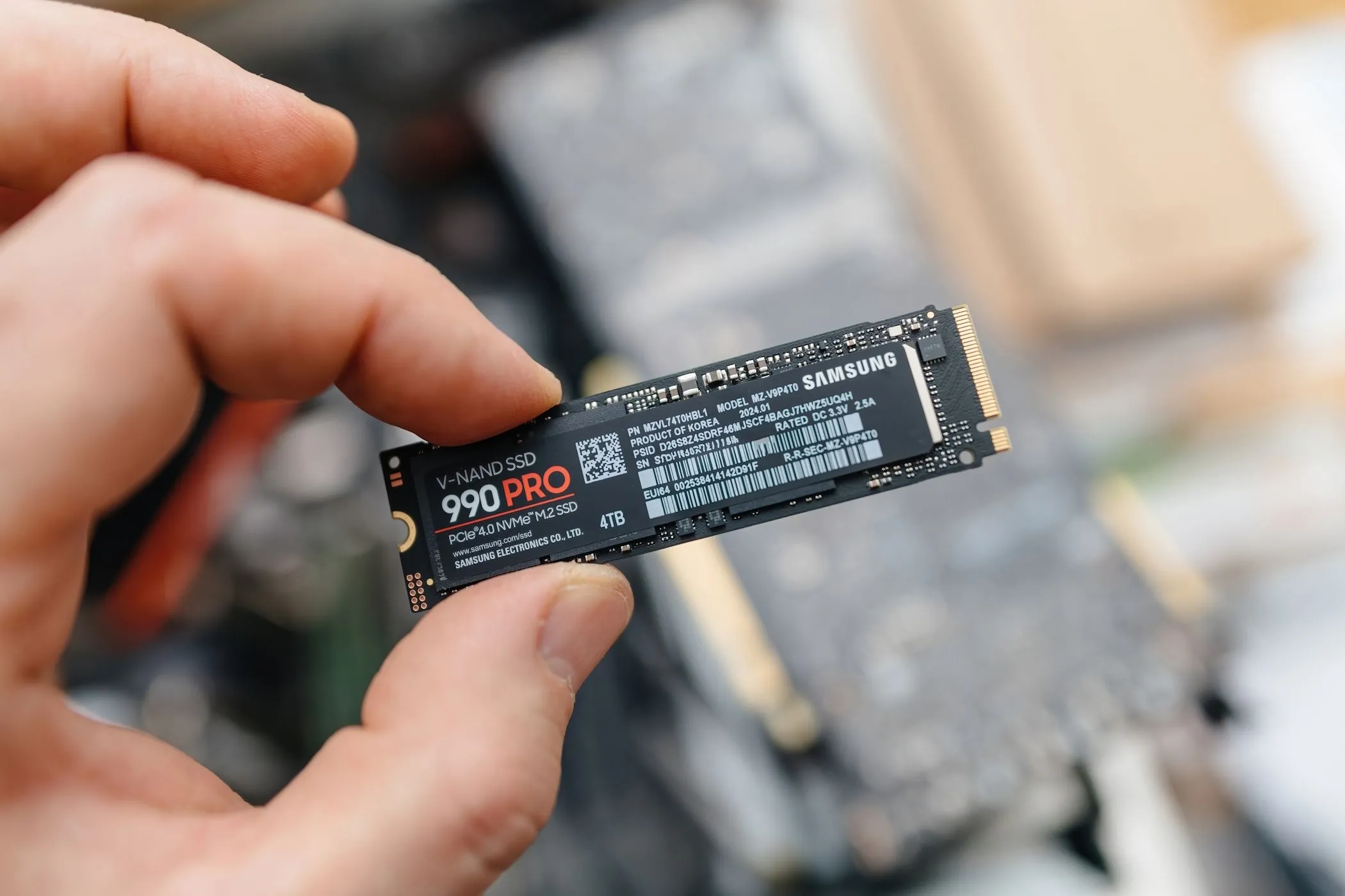 Người đàn ông cầm ổ cứng SSD NVMe Samsung 990 Pro, minh họa cho giải pháp nâng cấp hiệu suất máy tính hiệu quả hơn ReadyBoost