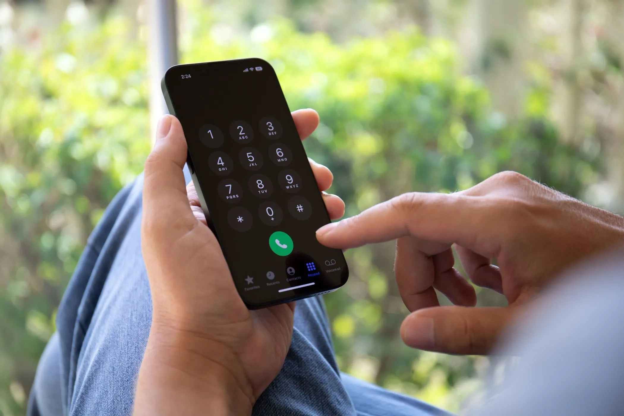 Người đàn ông nhập số điện thoại trên iPhone, thể hiện sự phụ thuộc của 2FA qua SMS vào số di động