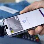 Người đàn ông sử dụng Apple Pay trên iPhone để thanh toán giao dịch tại cửa hàng.