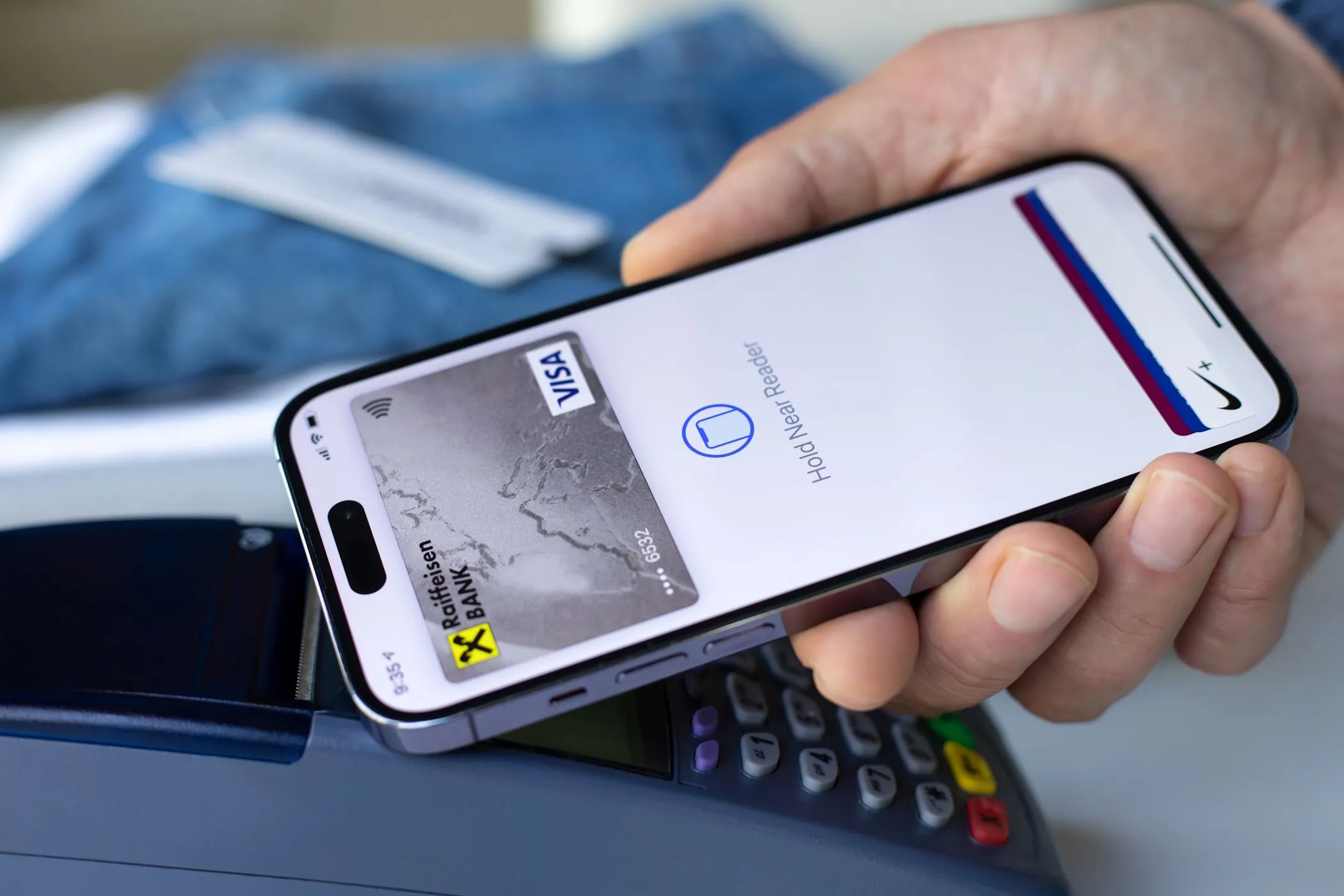 Người đàn ông sử dụng Apple Pay trên iPhone để thanh toán giao dịch tại cửa hàng.