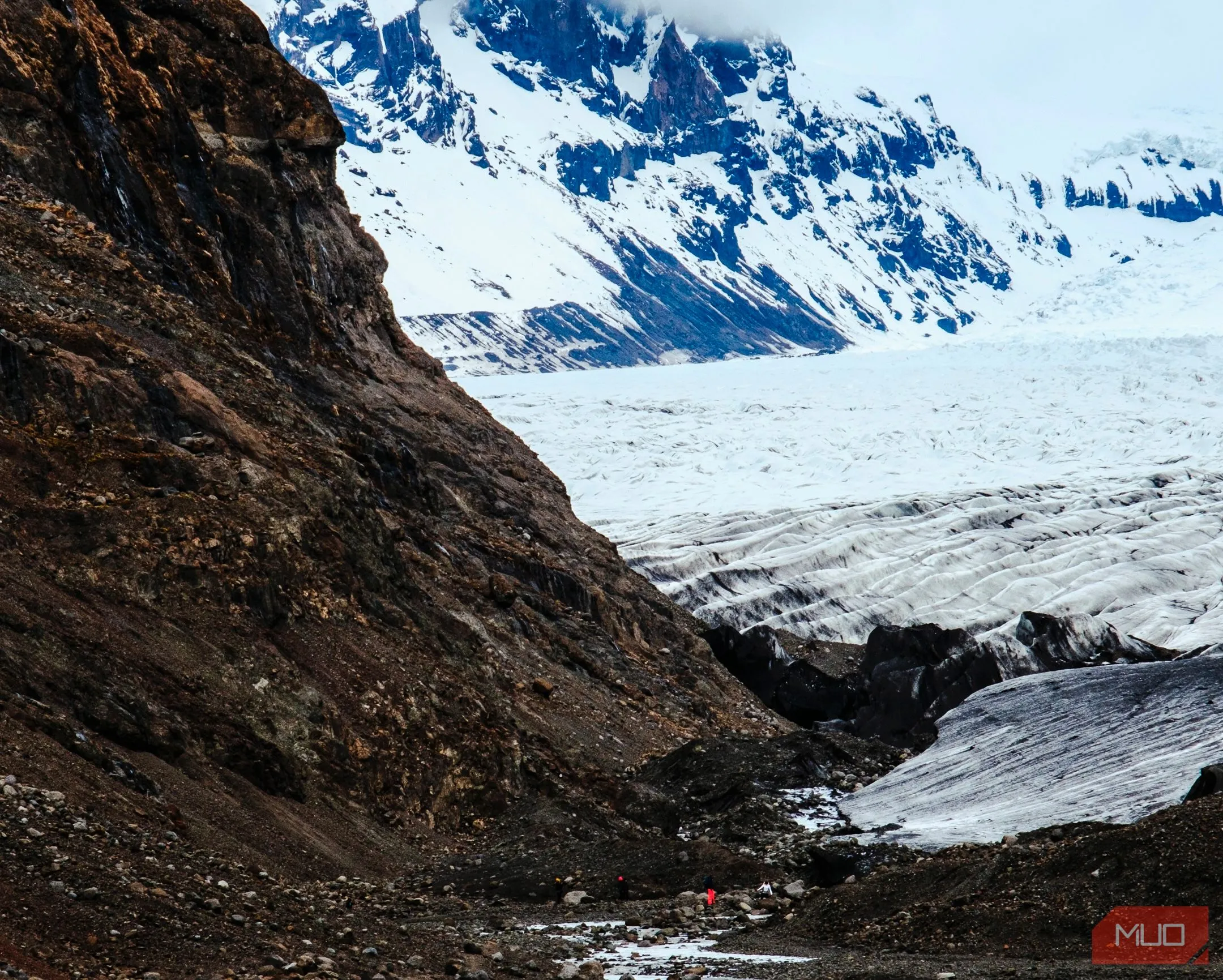 Người đang đi bộ giữa sông băng và núi non hùng vĩ trong công viên quốc gia Iceland