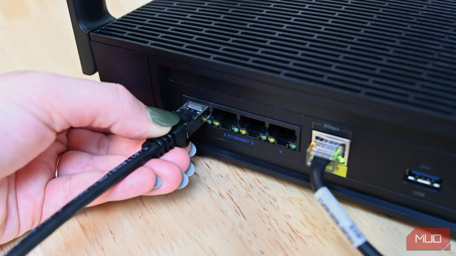 Người dùng cắm cáp Ethernet vào bộ định tuyến, minh họa cho giải pháp kết nối mạng có dây ổn định.