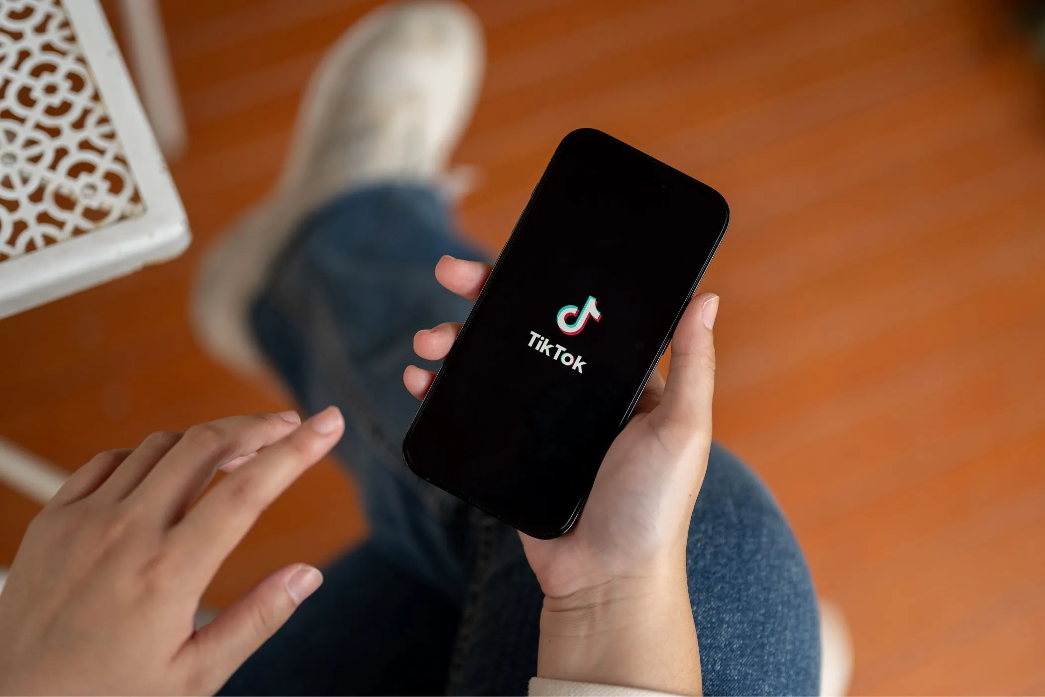 Người dùng đang cầm điện thoại hiển thị ứng dụng TikTok, minh họa ứng dụng mạng xã hội có rủi ro về thu thập dữ liệu cá nhân