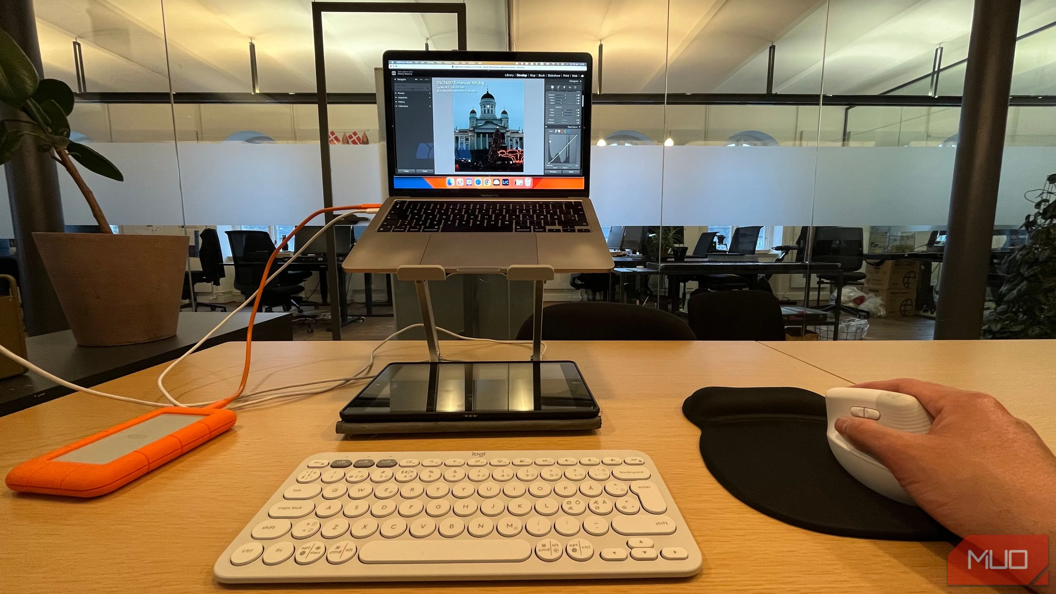 Người dùng đang chỉnh sửa ảnh trên laptop bằng chuột không dây, thể hiện sự chính xác và thoải mái khi làm việc đồ họa.