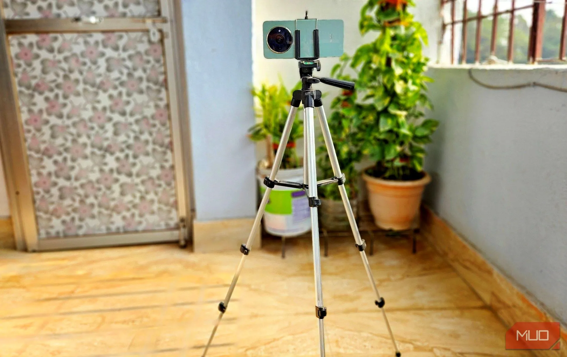 Người dùng đang gắn điện thoại lên chân máy (tripod) để chụp ảnh phong cảnh đêm đường phố, giúp ổn định máy và tránh rung mờ
