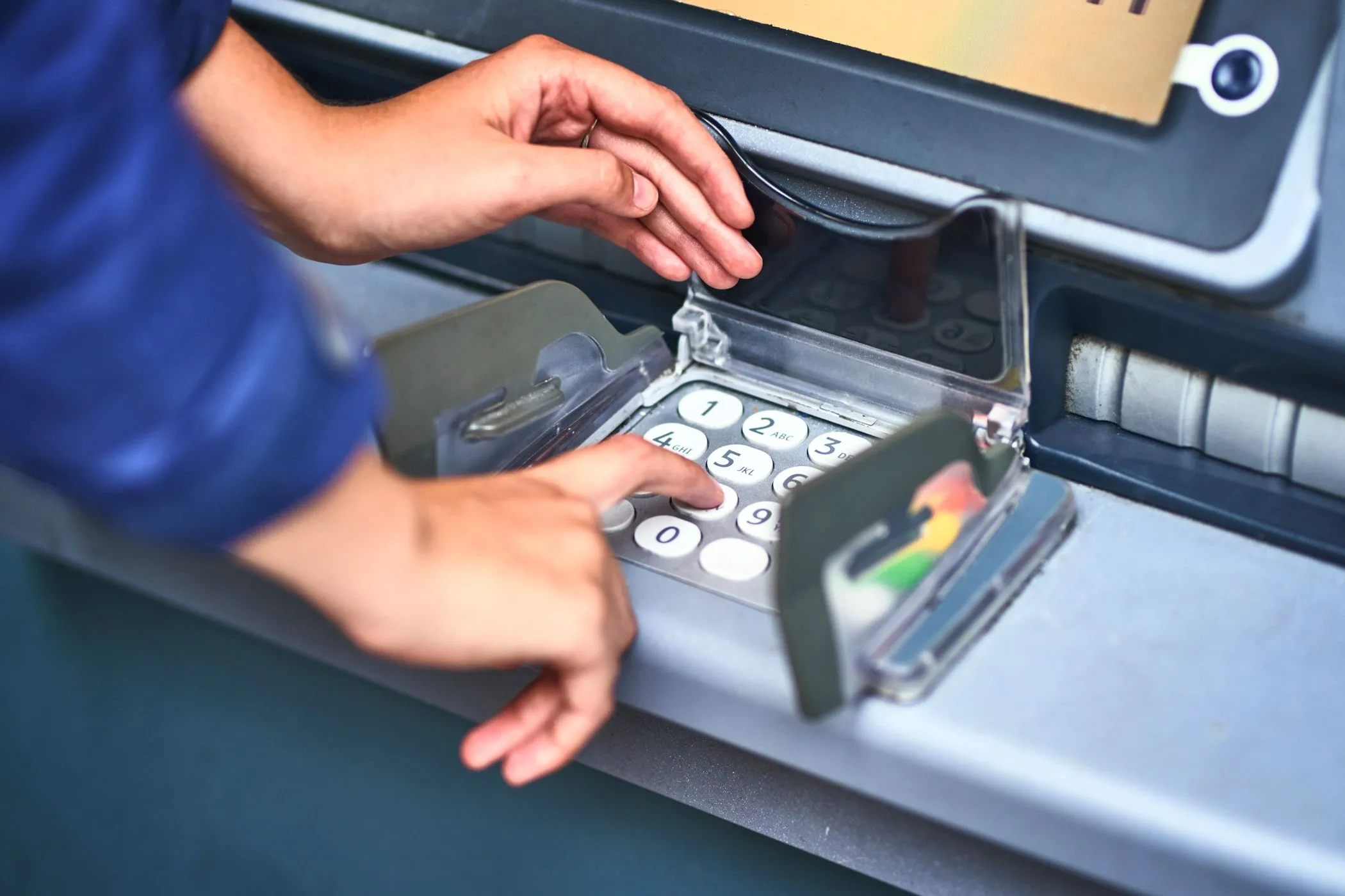 Người dùng đang nhập mã PIN trên bàn phím máy ATM, cần cảnh giác với các thiết bị skimming.