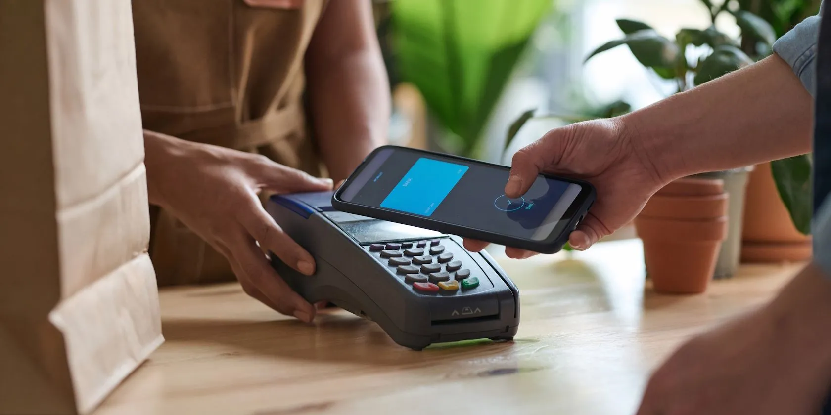 Người dùng đang thanh toán không tiếp xúc bằng điện thoại thông minh tại quầy thanh toán siêu thị qua chip NFC