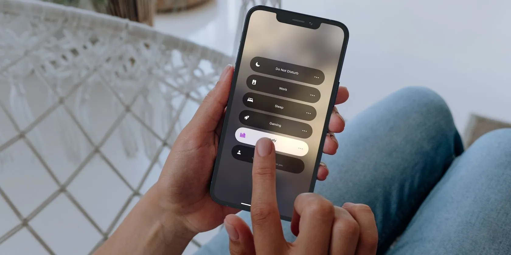 Người phụ nữ đang sử dụng iPhone 12 Pro với chế độ Tập trung (Focus Mode) được kích hoạt để cải thiện sự tập trung.