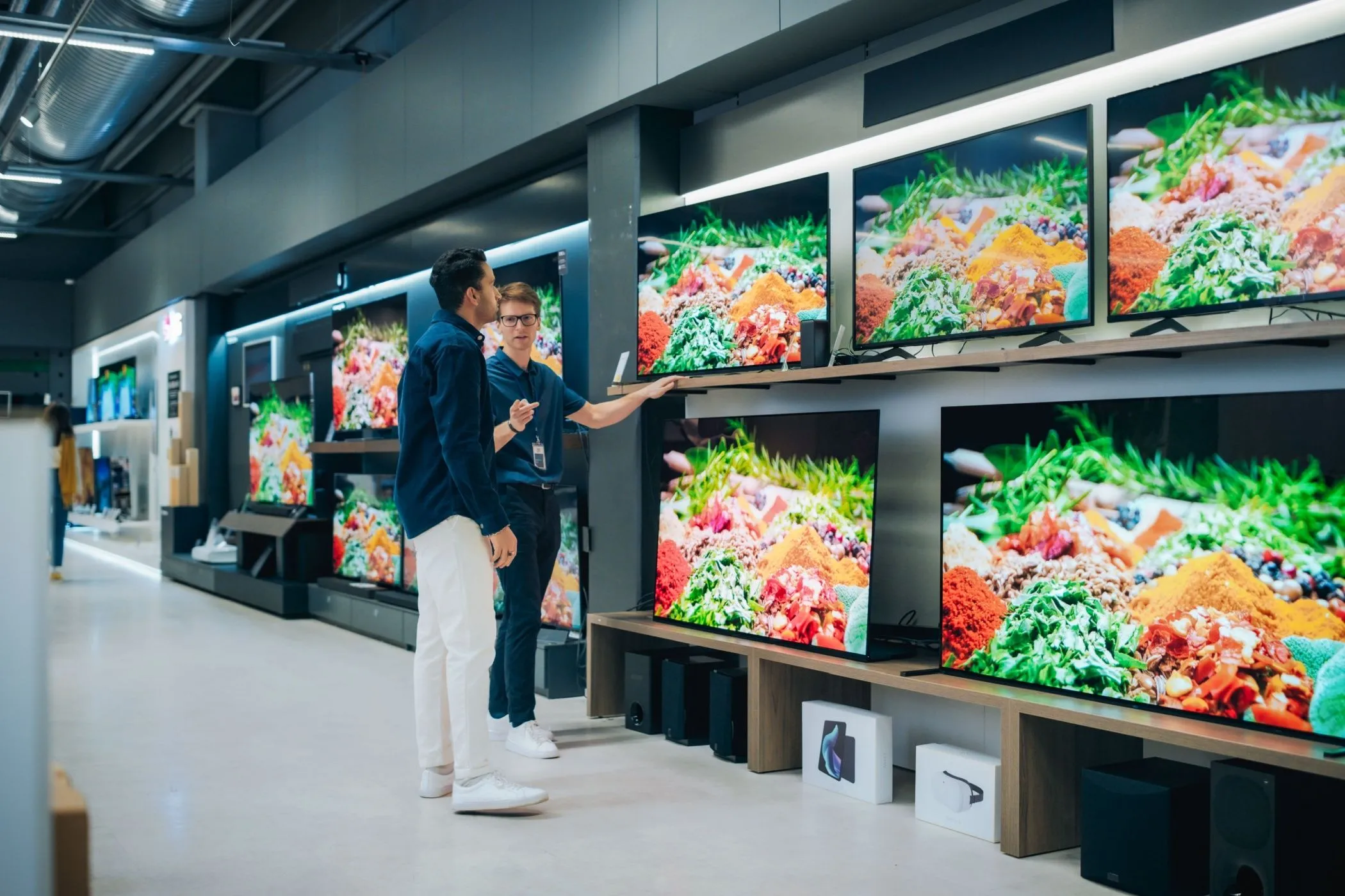 Nhân viên cửa hàng đang tư vấn về TV cho khách hàng.