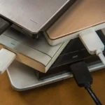 Nhiều ổ cứng di động và ổ cứng ngoài đặt cạnh laptop, minh họa sự phức tạp khi quản lý nhiều phân vùng.