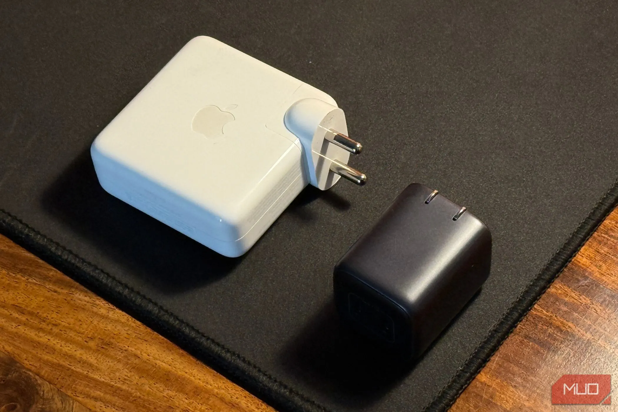 So sánh củ sạc điện thoại du lịch nhỏ gọn GaN với củ sạc MacBook lớn, thể hiện sự tiện lợi khi di chuyển
