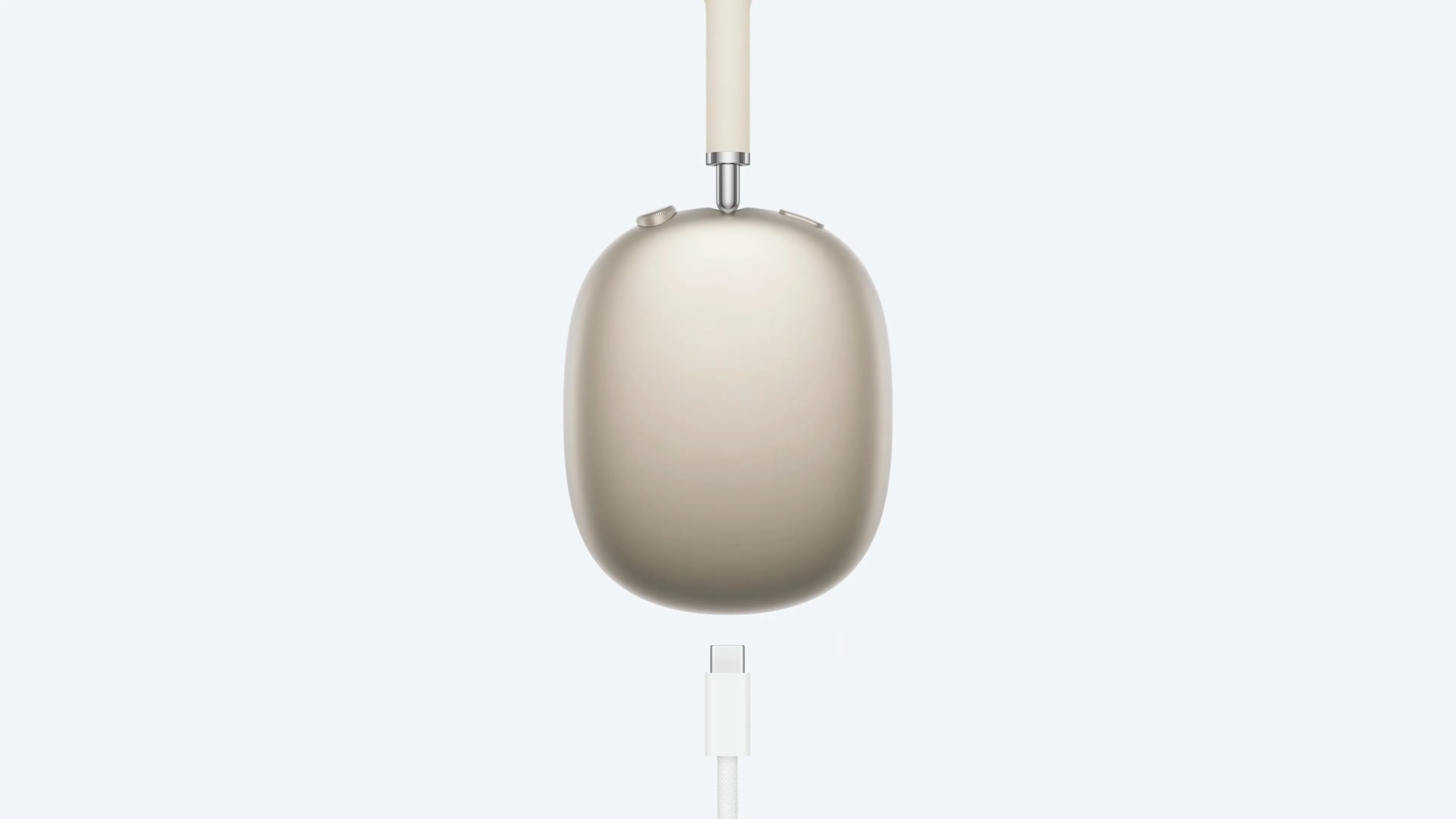 Tai nghe AirPods Max màu Starlight đang sạc qua cổng USB-C