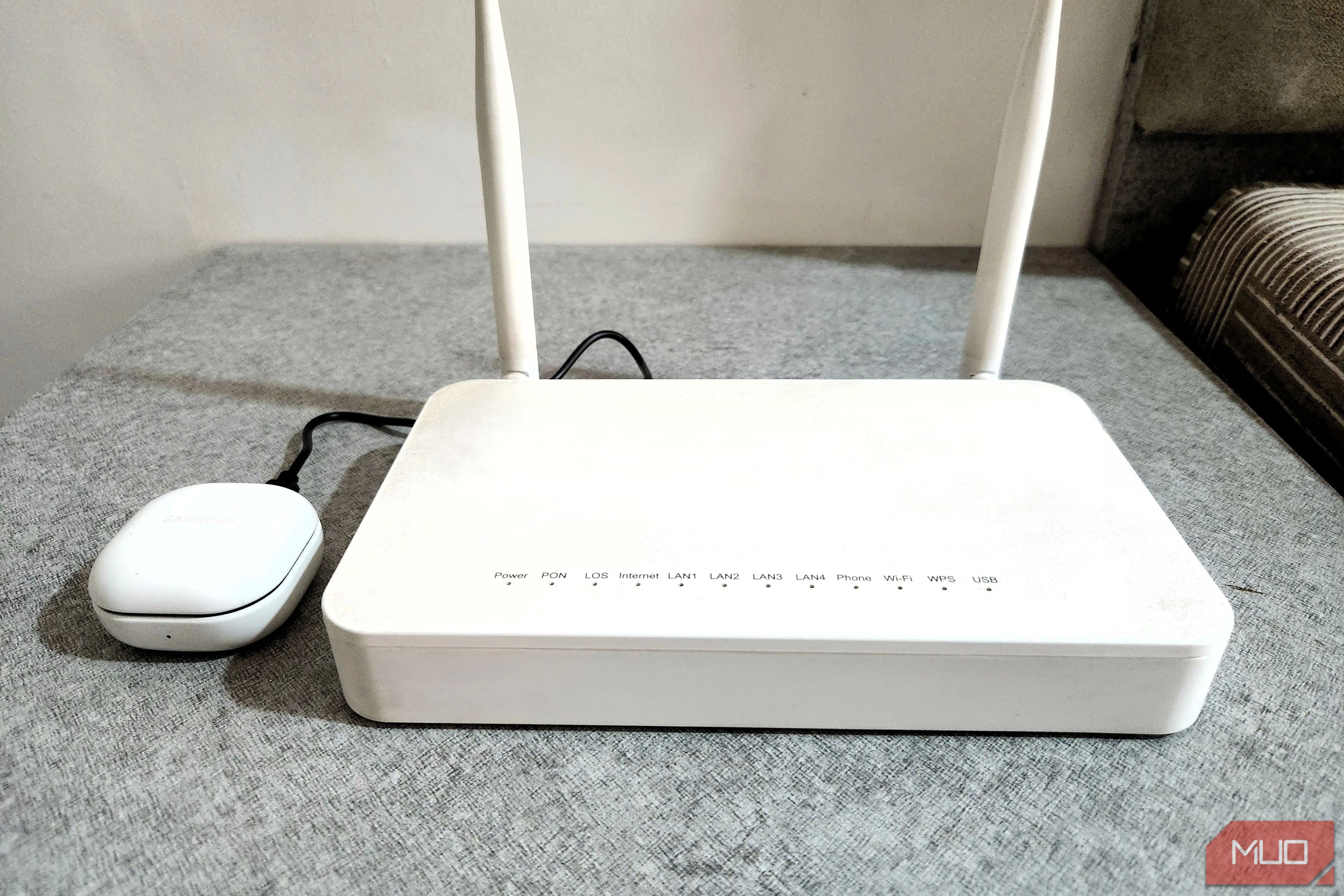 Tai nghe Bluetooth đang được sạc qua cổng USB trên router.