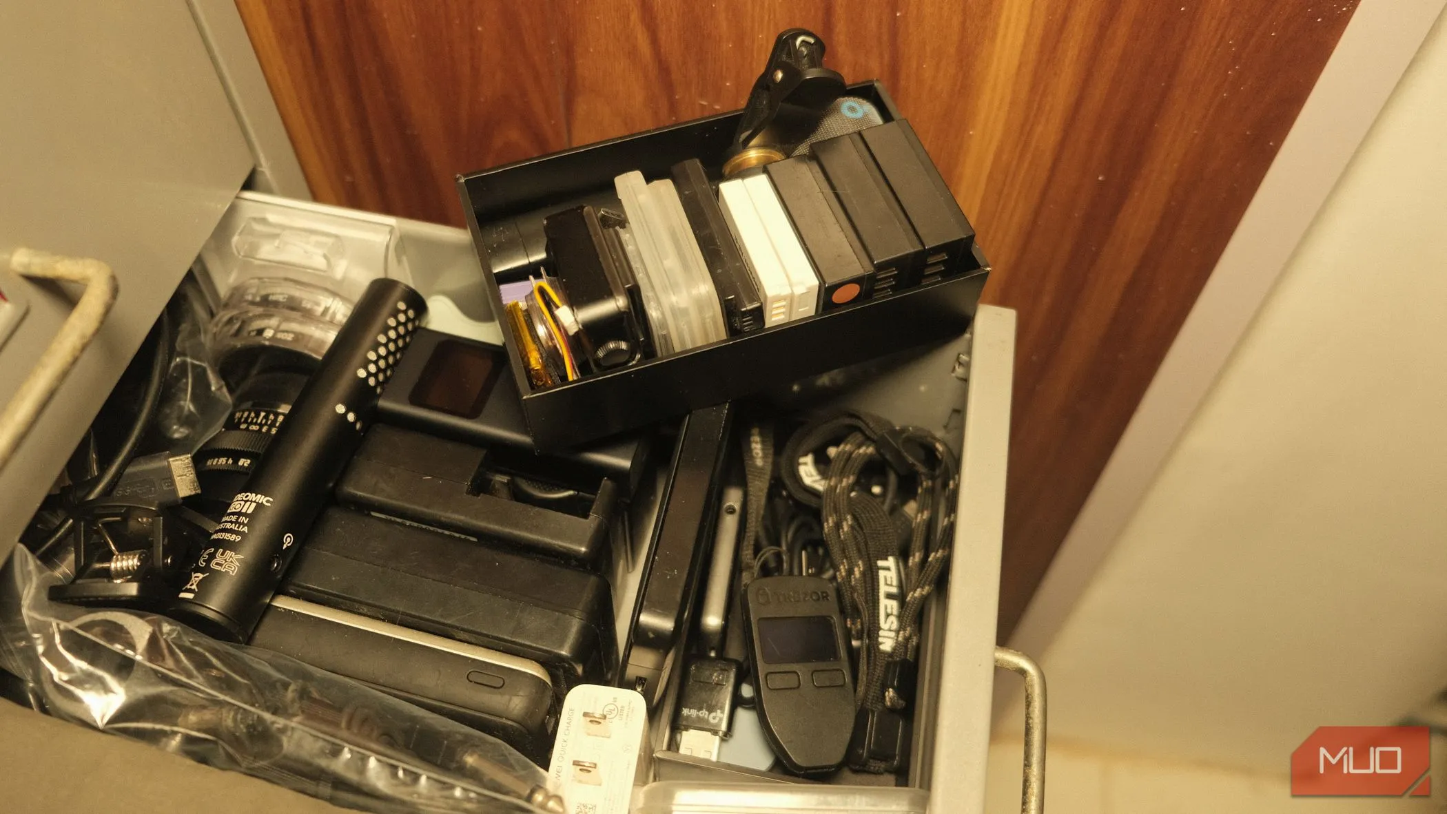 Tạo ngăn chứa bí mật bên dưới hộp pin máy ảnh để lưu trữ các vật dụng ít dùng hoặc cần bảo mật như ví lạnh Trezor và các loại cáp ngắn.