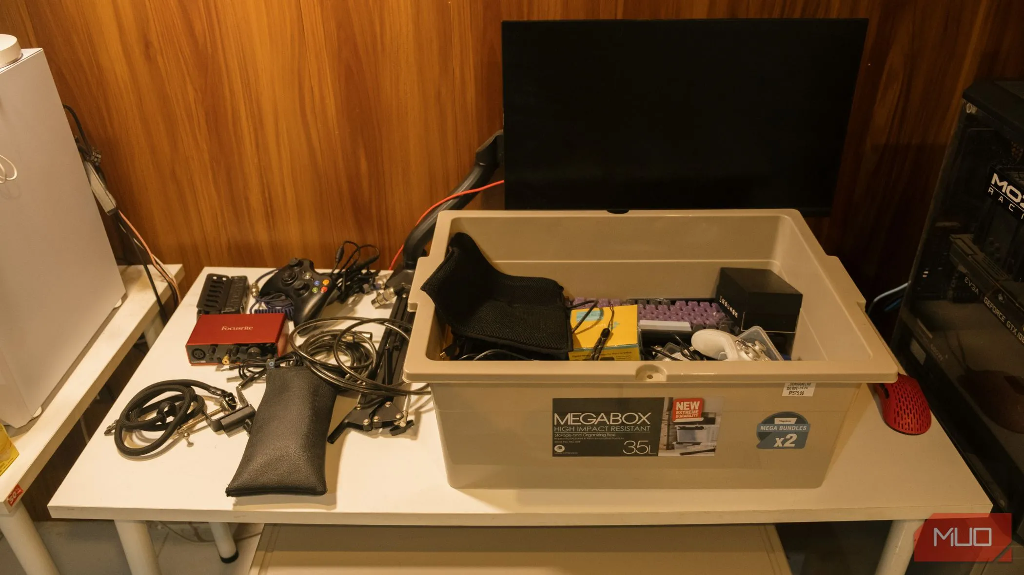 Tất cả thiết bị và phụ kiện công nghệ được thu gom vào một chiếc hộp lớn trước khi sắp xếp, thể hiện sự lộn xộn ban đầu cần giải quyết.