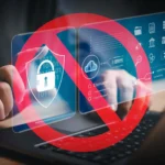 Tay gõ bàn phím laptop với biểu tượng cấm che các icon bảo mật, minh họa rủi ro bảo mật mật khẩu yếu.